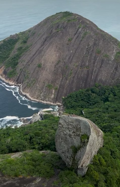 Vista aérea frontal da Agulha Guarischi mostrando o granito e o Atlântico em Niterói, RJ