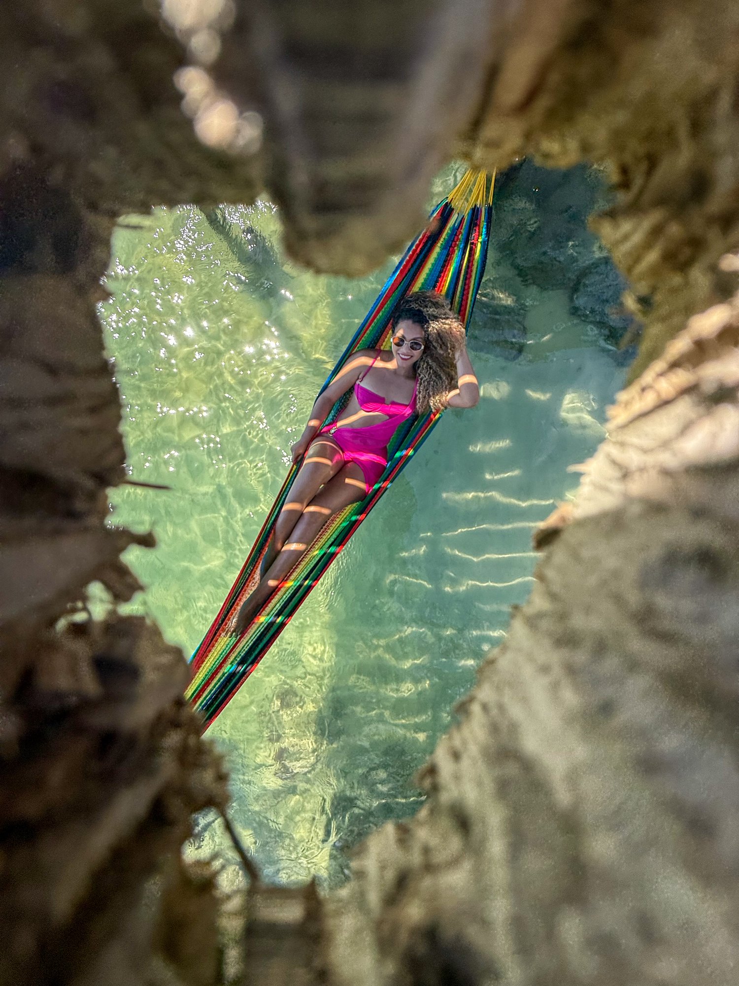 Mulher em rede sobre piscina natural entre rochas em Arraial do Cabo