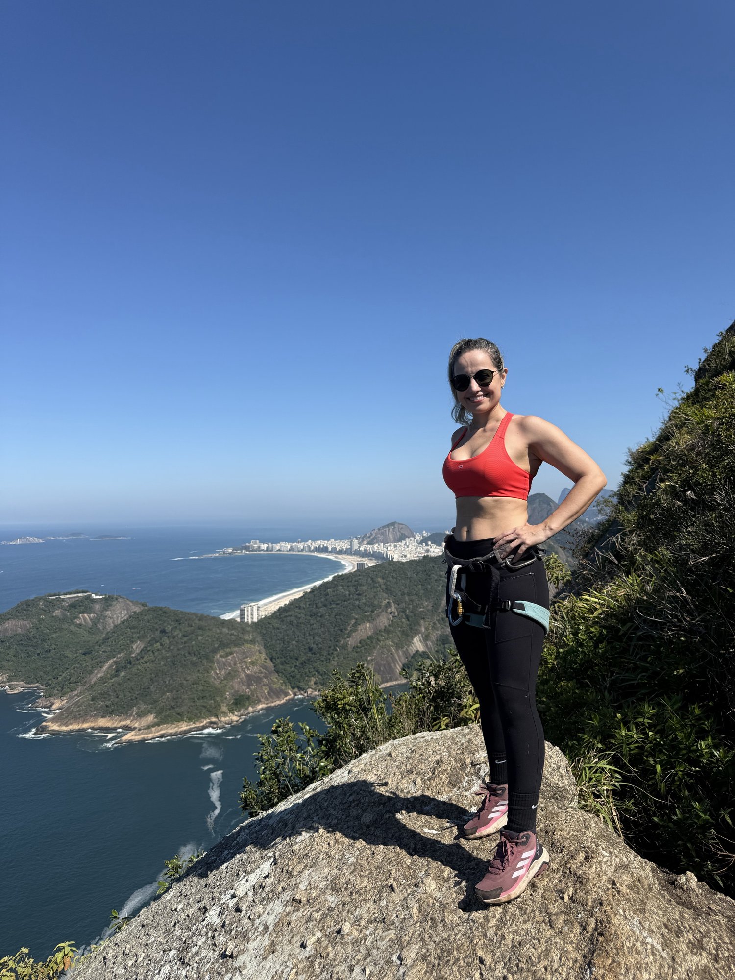 Escalador na face de granito do Costão do Pão de Açúcar com vista da Baía de Guanabara