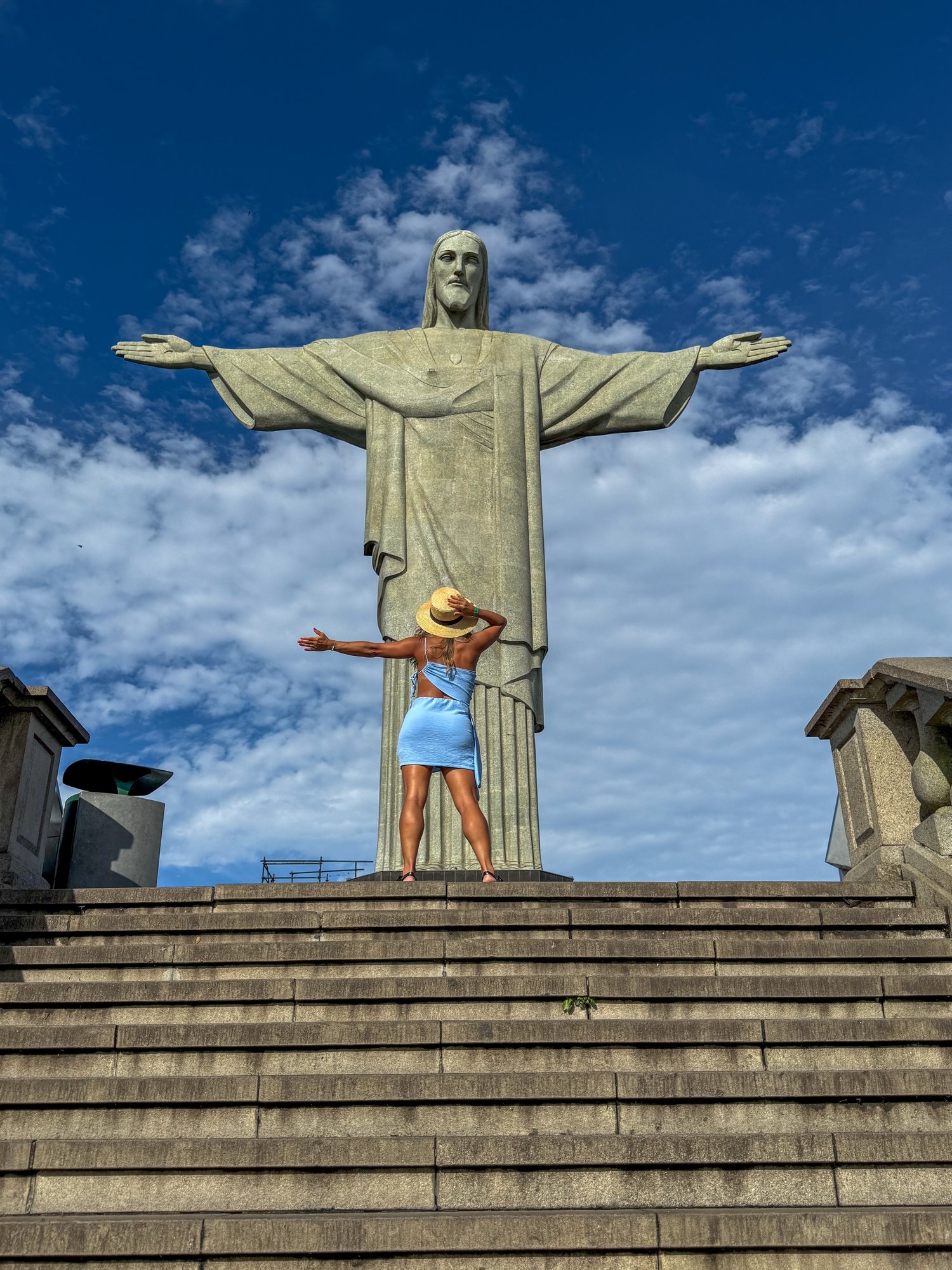 Visitante com vestido verde no mirante do Corcovado com vista panorâmica do Pão de Açúcar e a baía