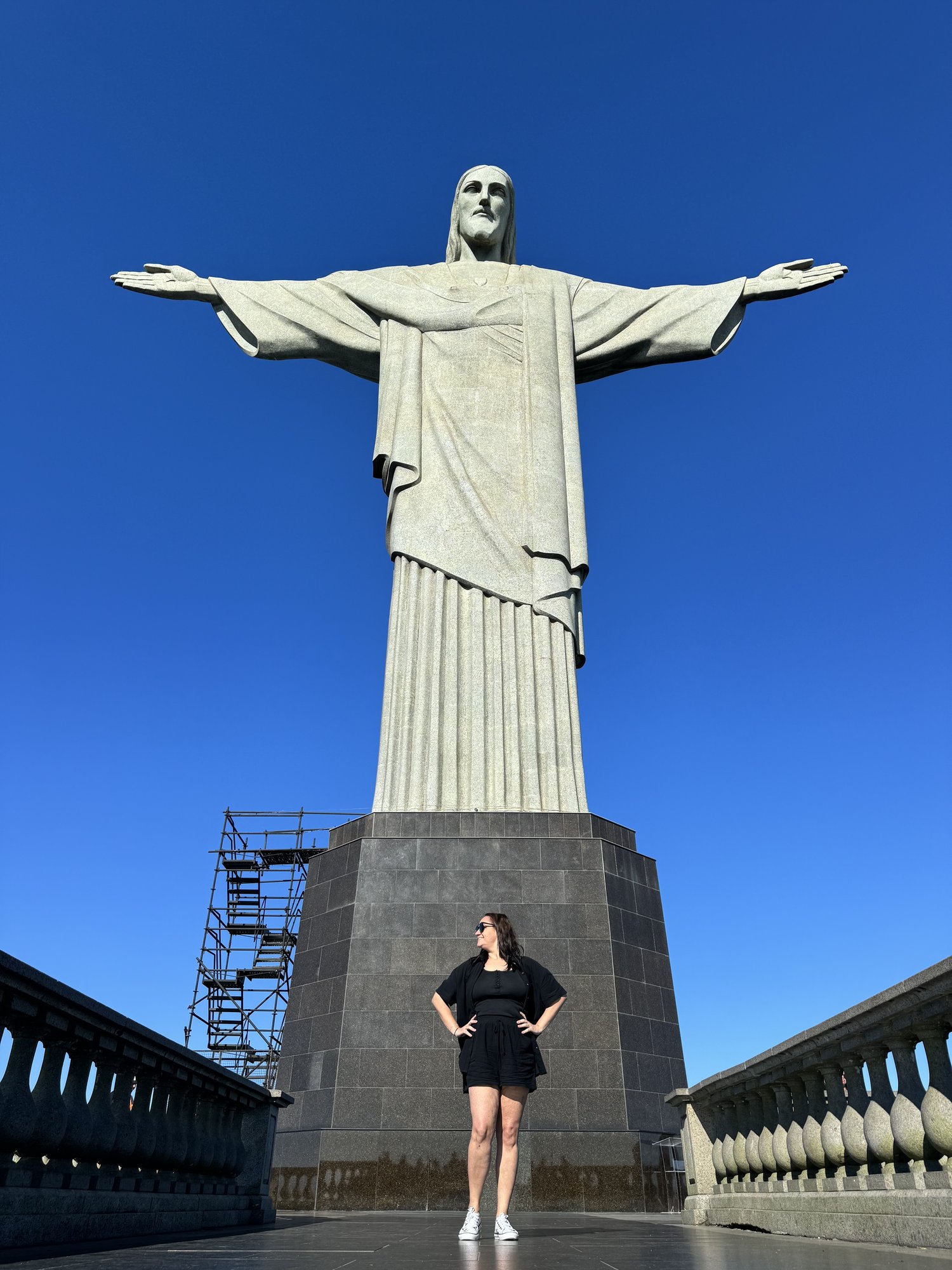 Vista do Cristo Redentor a partir das escadarias com mata atlântica e andaimes de restauração visíveis