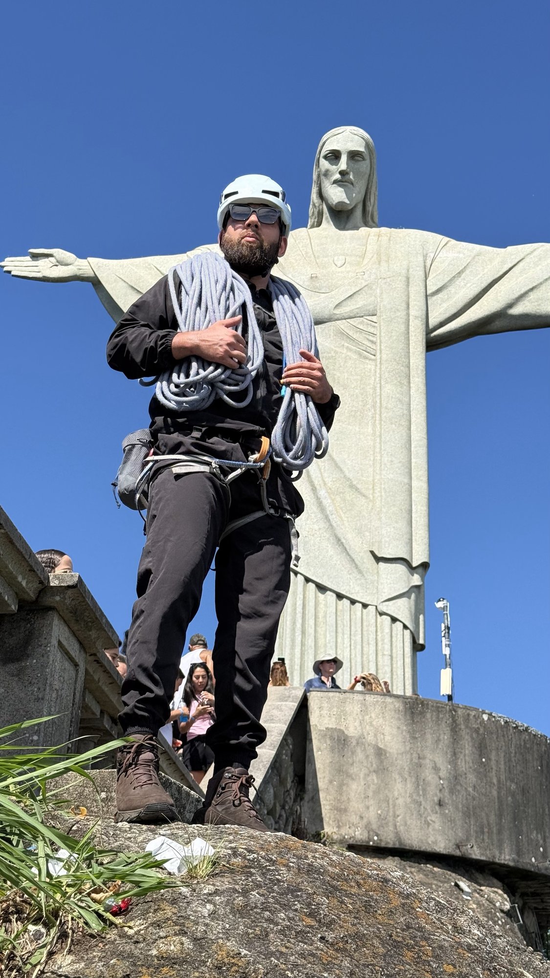 Escalador em pitch vertical na Via K2 do Corcovado com floresta da Tijuca ao fundo