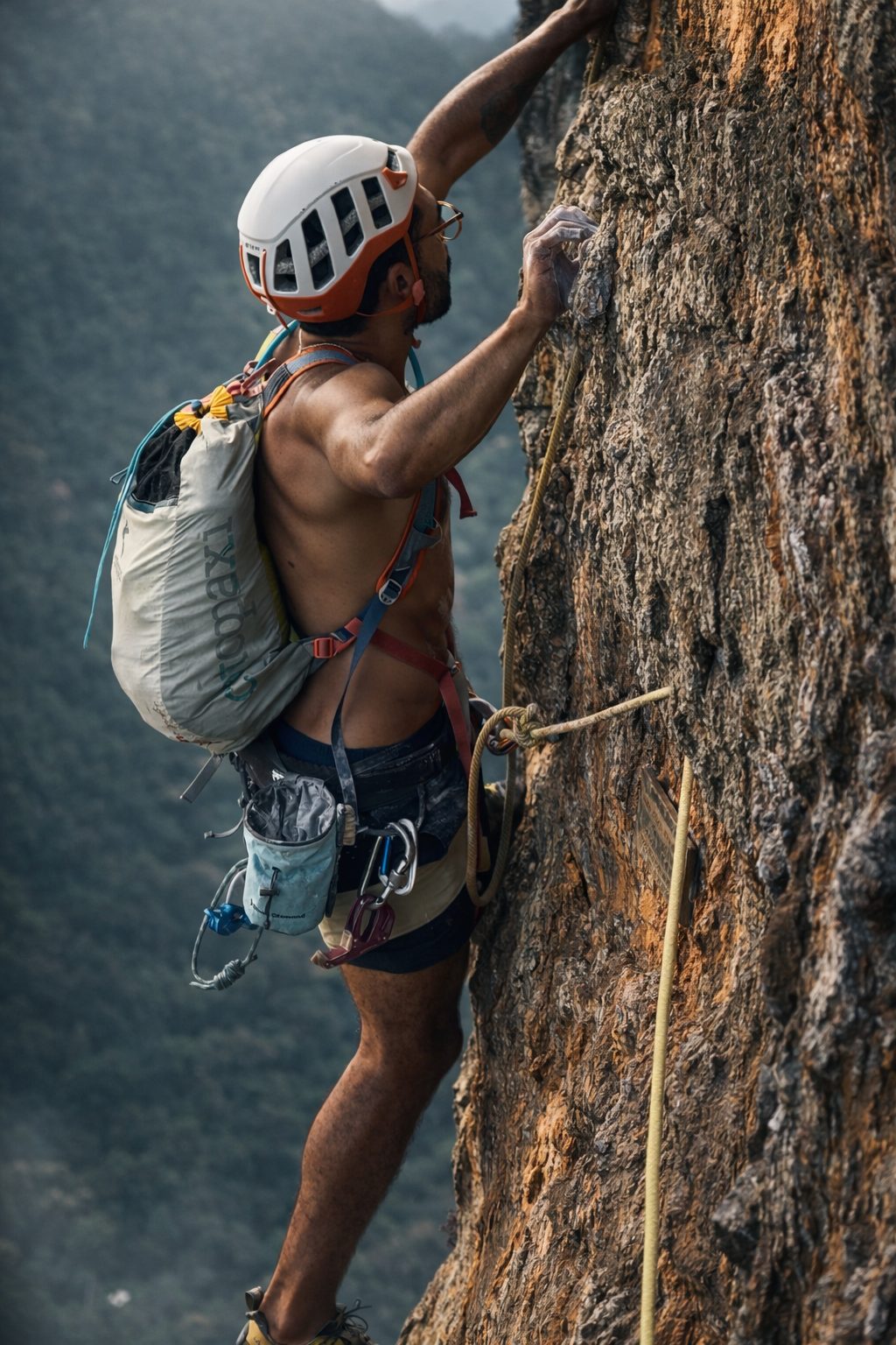 Dois escaladores na parede da Pedra da Gávea sob as formações rochosas Passagem dos Olhos com o oceano Atlântico ao fundo