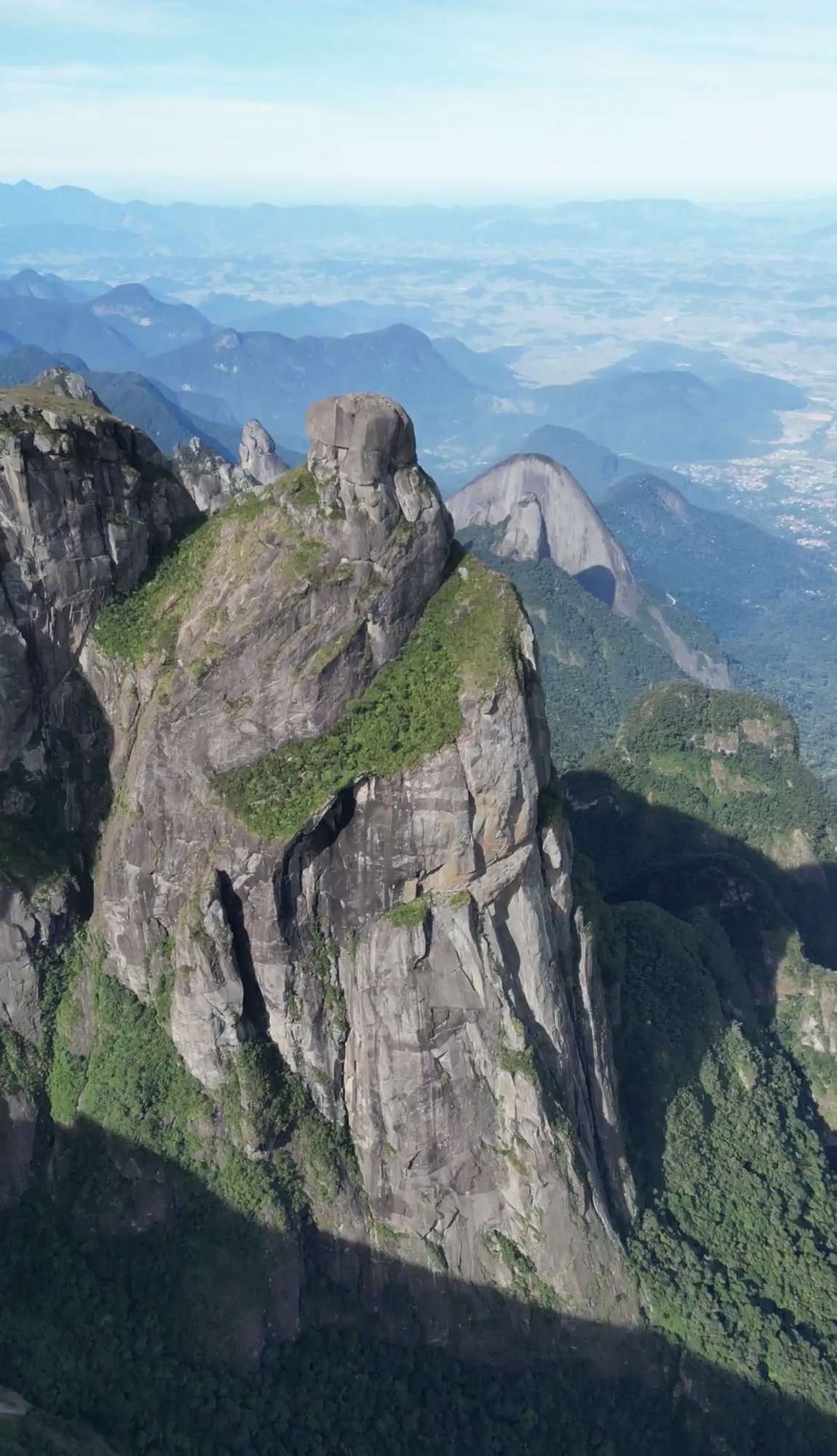 Vista aérea da torre do Garrafão com o cume em forma de garrafa e a paisagem da Serra dos Órgãos ao redor