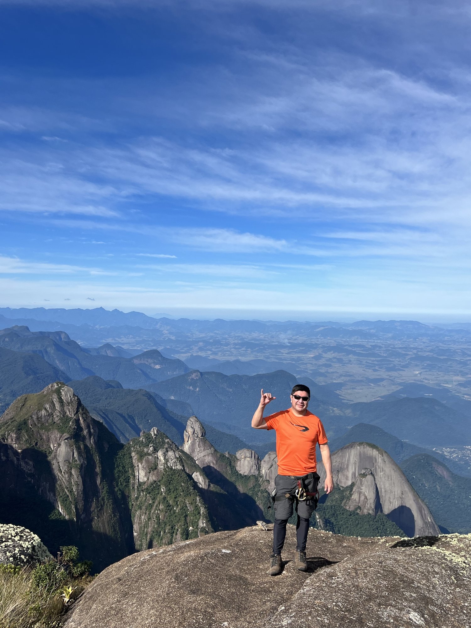 Escalada em fissura de granito no Garrafão com vegetação de alta montanha e vale da Serra dos Órgãos ao fundo