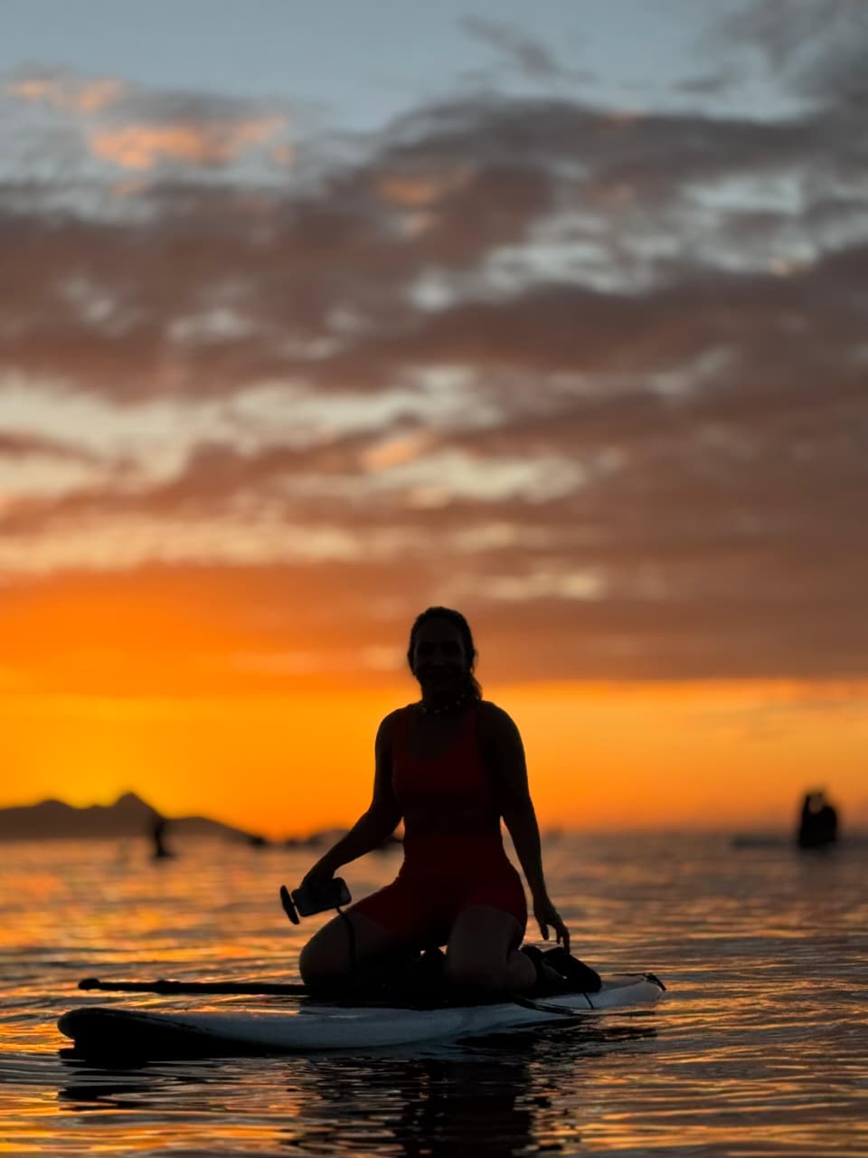 Silhueta de praticante de Stand Up Paddle no mar de Copacabana sob o céu dramático do amanhecer
