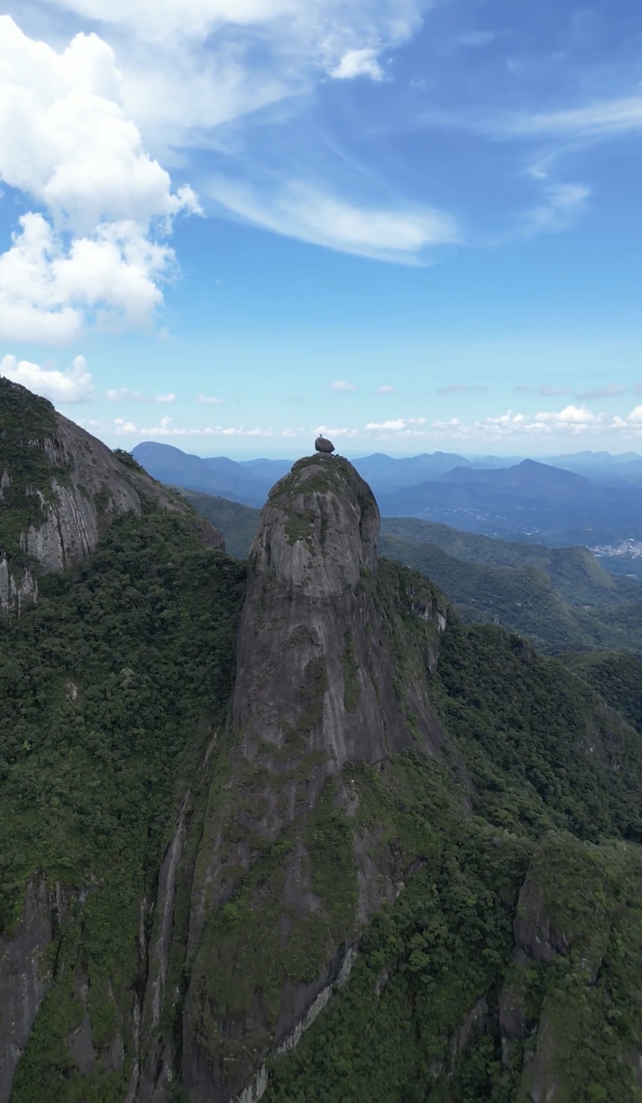 Vista aérea da torre da Verruga do Frade com o bloco arredondado no topo e a floresta da Serra dos Órgãos ao redor